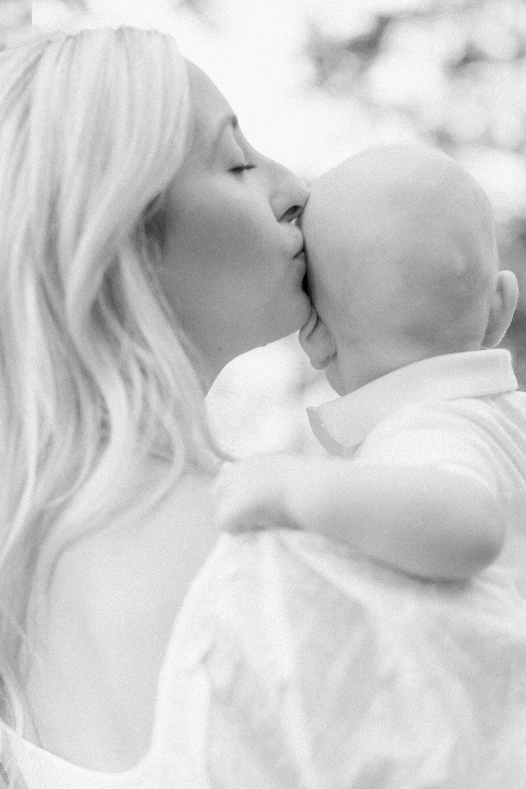 Familjefotografering i Västerås där mamman pussar sin lilla son på huvudet