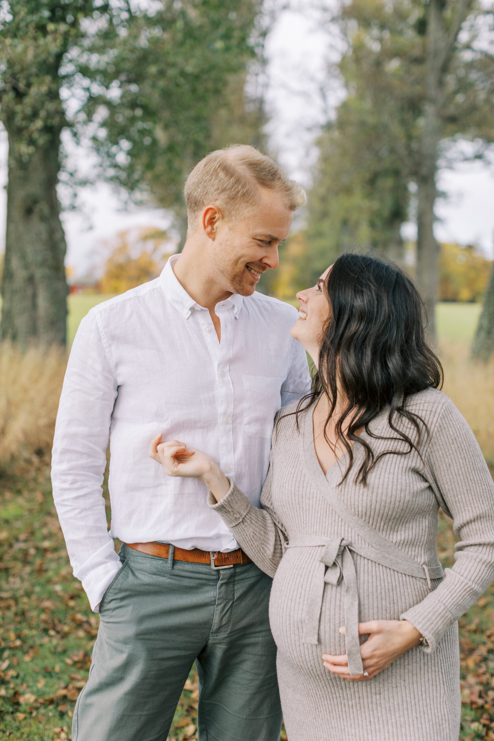 Gravidfotografering i Västerås där paret tittar på varandra och ler