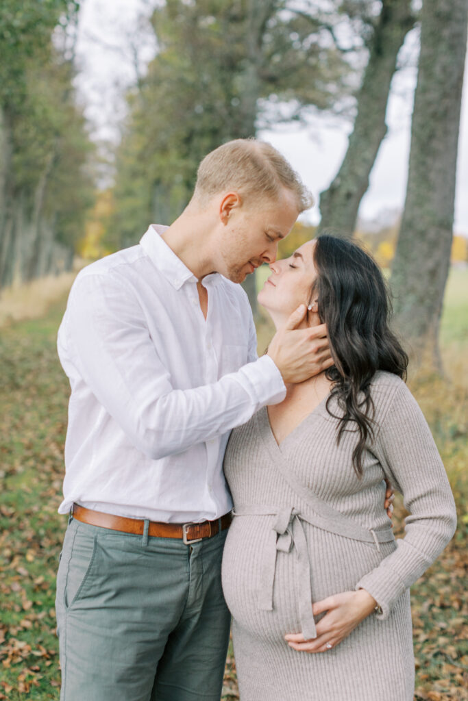 Gravidfotografering i Västerås där paret står nära varandra och myser